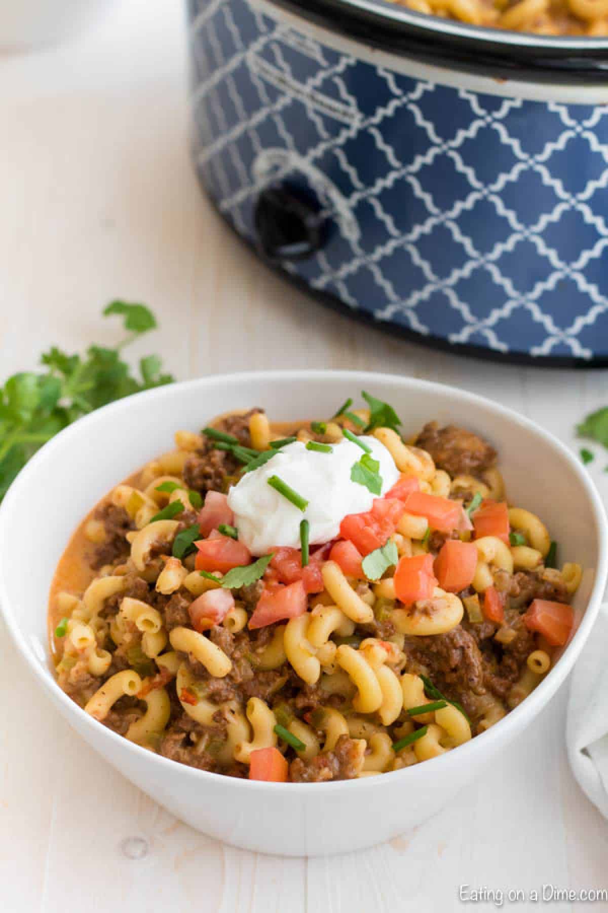 Everything you need for a tasty meal is in this Crock Pot Beef Taco Pasta Recipe. Loaded with cheese, ground beef and tons of taco flavor for an easy meal. Crock pot beef taco pasta in a bowl.