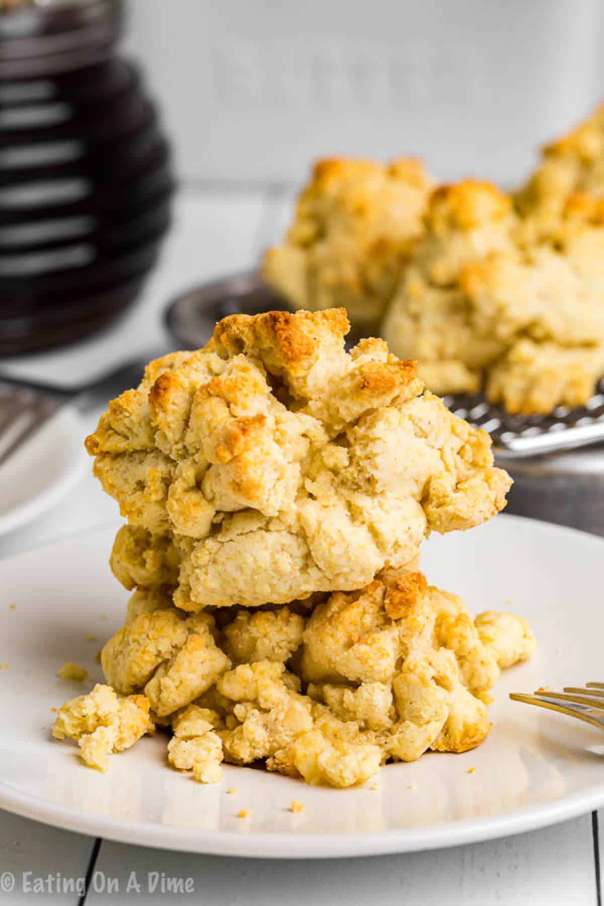 These simple gluten free biscuits will be your new go-to recipe! No one will even miss the gluten. Since they're drop biscuits, you know they're easy! Gluten Free Biscuits golden brown stacked on a white plate