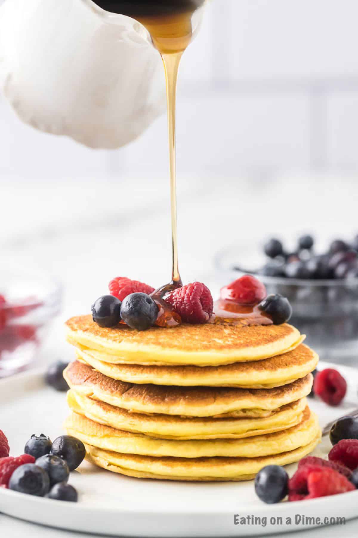 Greek Yogurt Pancakes stacked on a plate topped with blueberries and raspberries