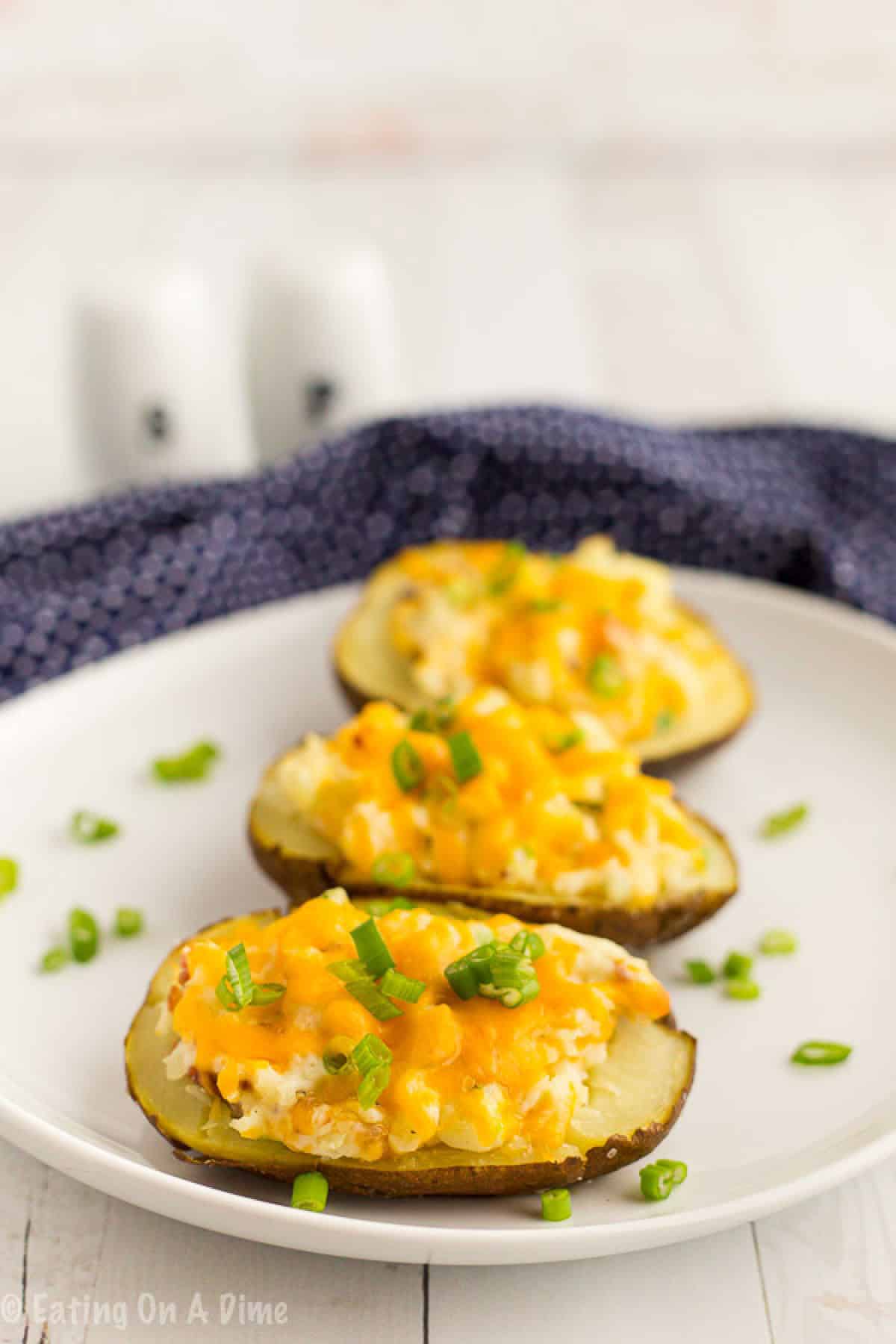Twice Baked Potatoes are so simple and make the perfect side dish. If you can make mashed potatoes, you can easily make these quick twice baked potatoes. Twice Baked Potatoes on a baking sheet