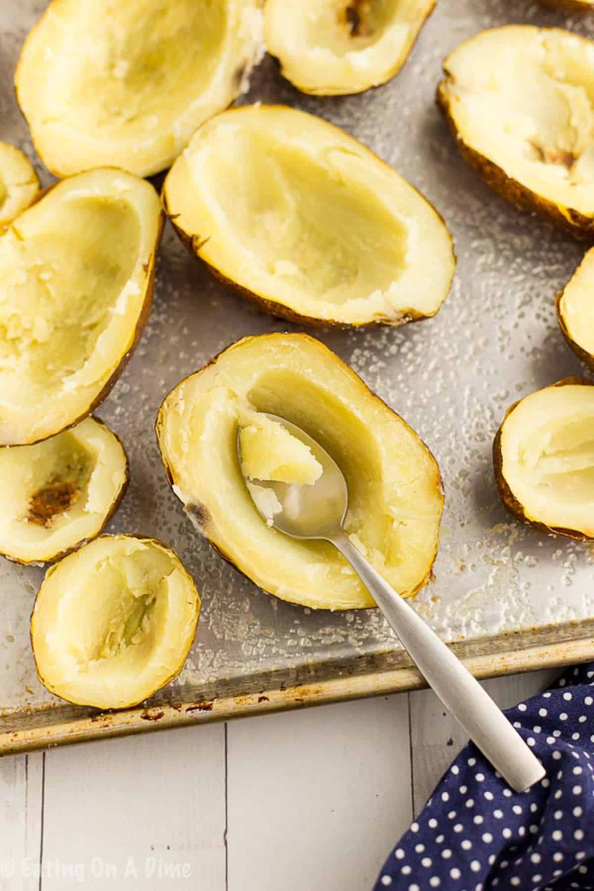 Spooning the cooked potatoes from the potato skin 