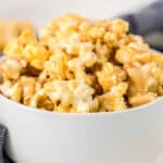 Homemade caramel marshmellow popcorn in a white bowl.