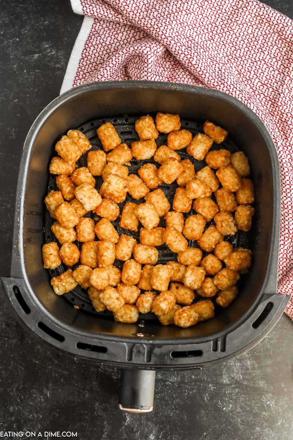 Placing tator tots in the air fryer basket