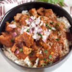 Beef Curry in a bowl topped with red onions.
