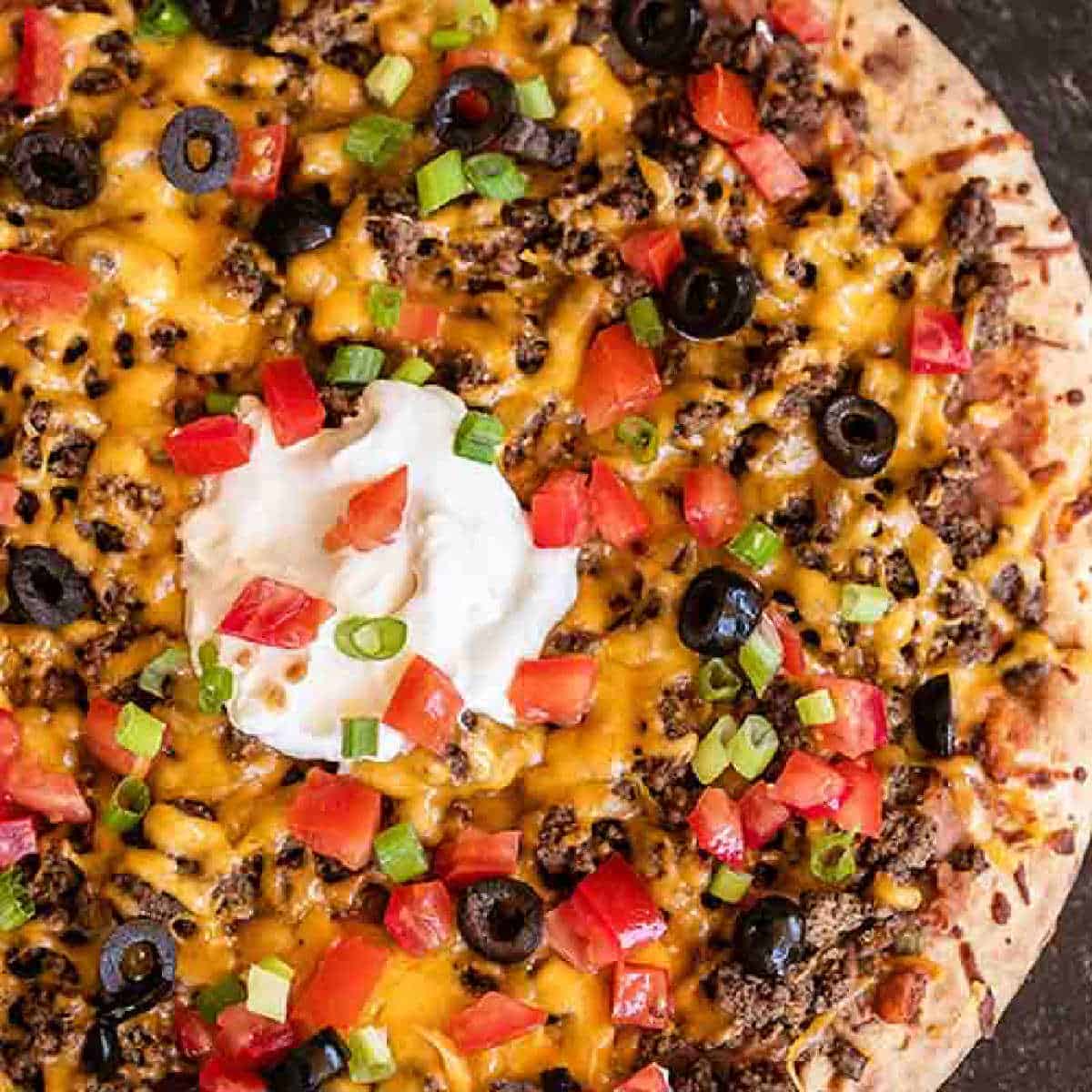 Our family loves this Taco pizza recipe with pizza crust and it is so easy to prepare. This easy homemade Mexican pizza with refried beans is loaded with so much flavor and tons of delicious toppings. #eatingonadime #tacopizzarecipe