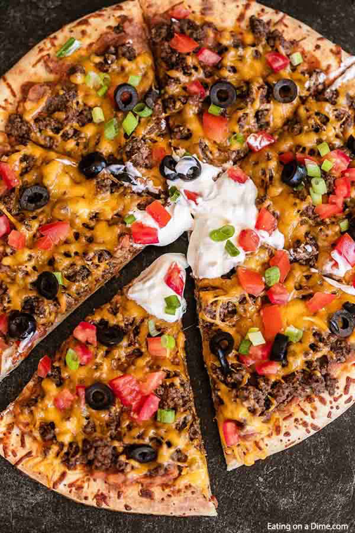 Our family loves this Taco pizza recipe with pizza crust and it is so easy to prepare. This easy homemade Mexican pizza with refried beans is loaded with so much flavor and tons of delicious toppings. #eatingonadime #tacopizzarecipe