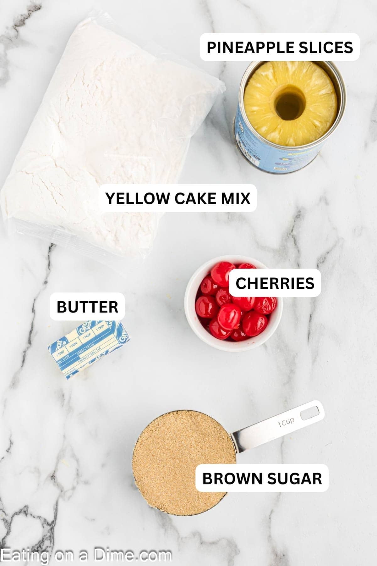 The ingredients required to make the recipe include cake mix, bowl of cherries, stick of butter, brown sugar, and pineapple slices.