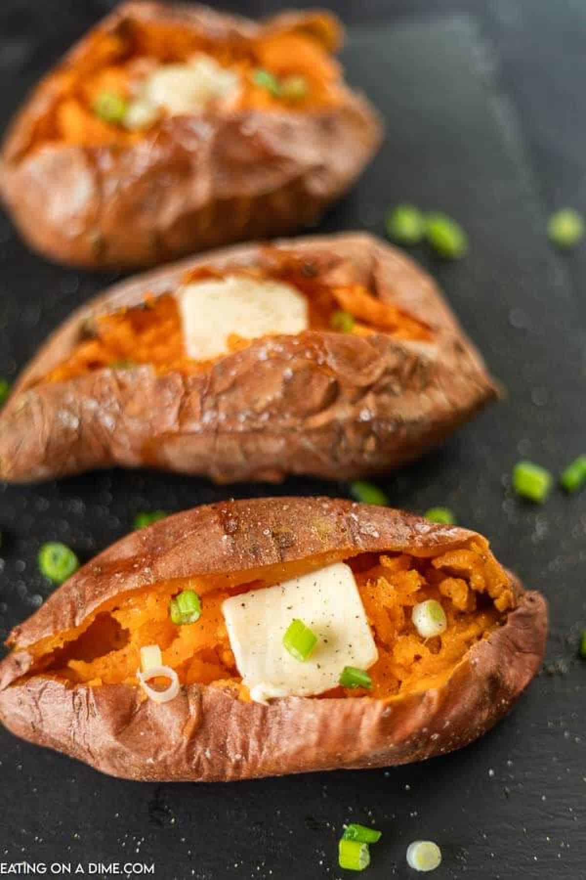Baked sweet potatoes topped with melted butter and chives