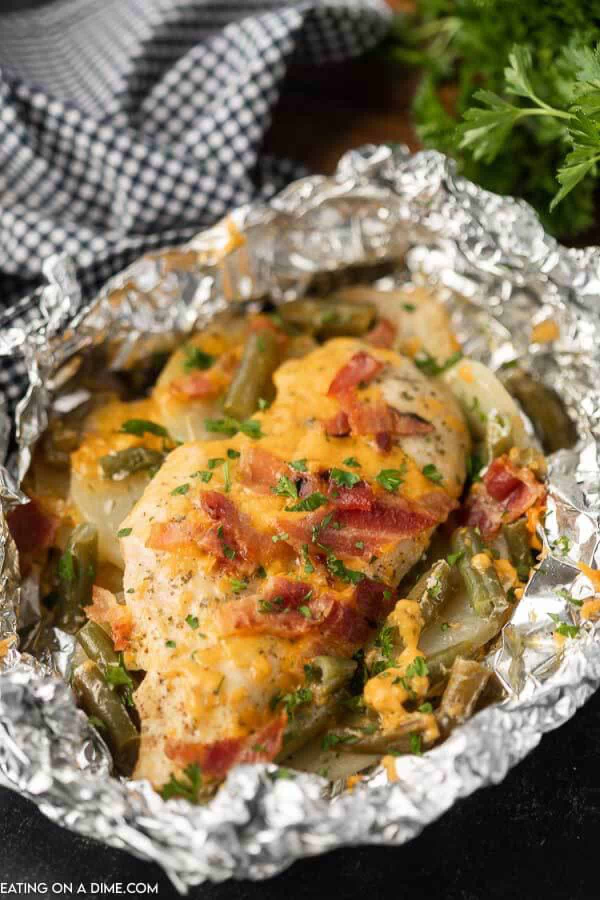 Bacon ranch chicken foil packet has everything you need for a great dinner. The juicy chicken and tender veggies make a meal sure to impress. Cooked chicken breast in foil topped with diced bacon, melted cheese green beans and slice potatoes