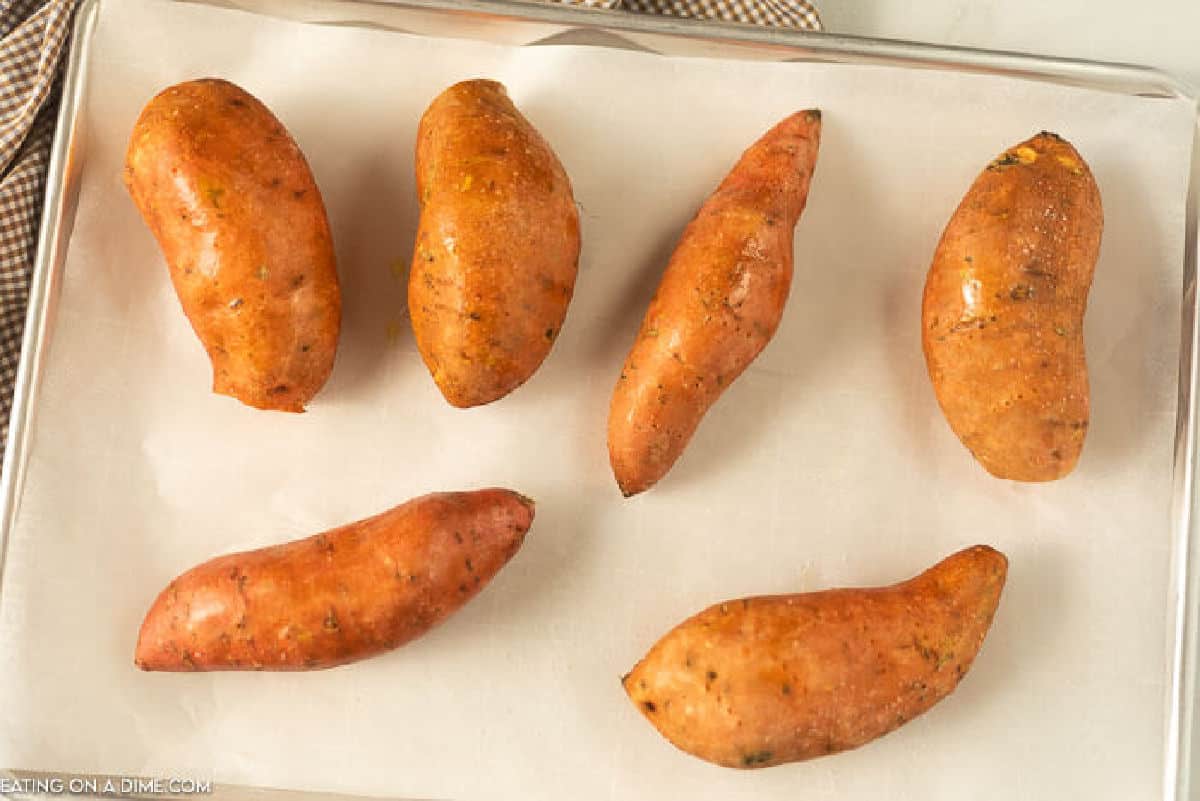 Sweet potatoes on a baking sheet lined with parchment paper