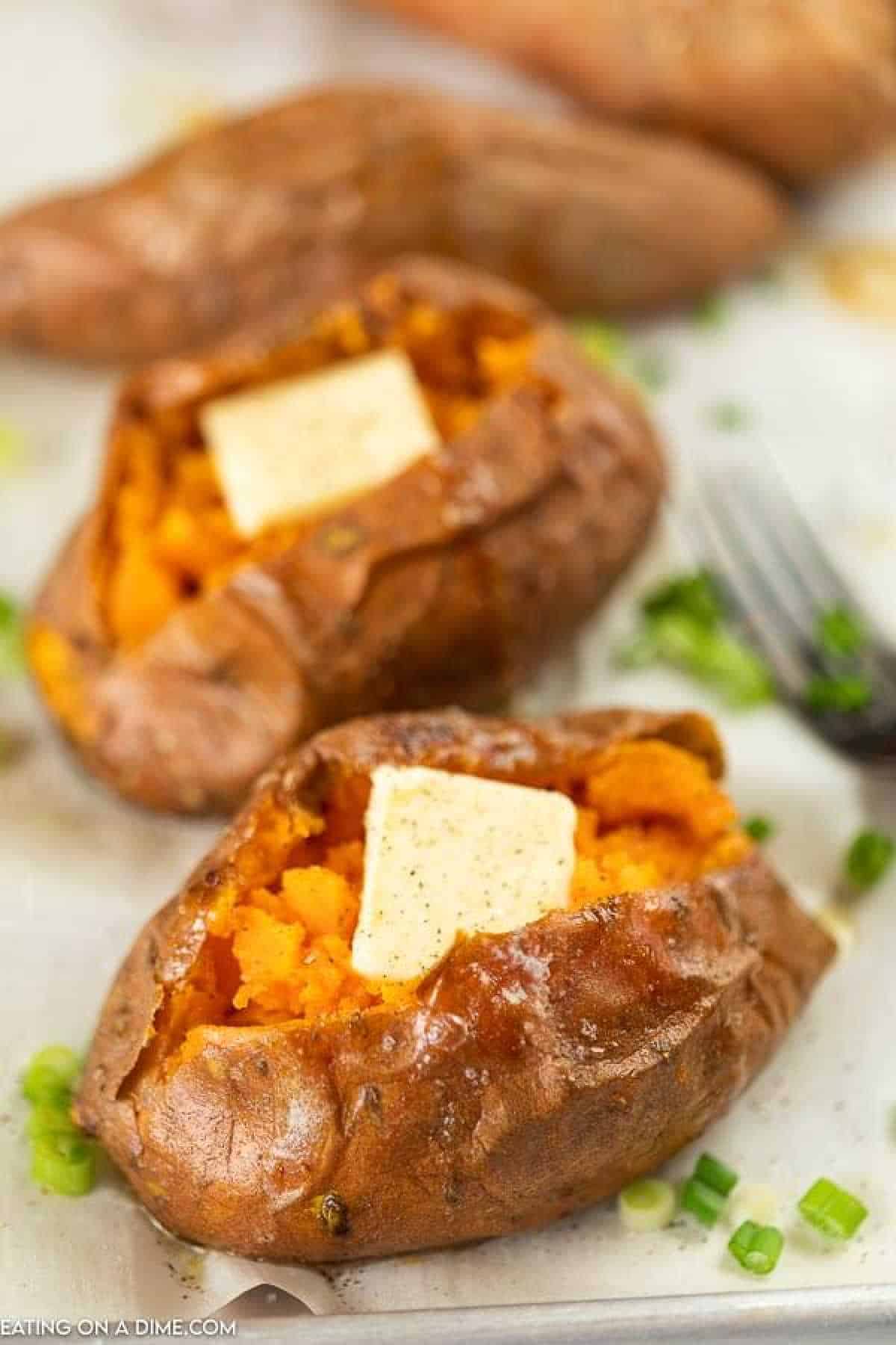 Learn how to bake sweet potatoes in the oven perfectly every time. Enjoy delicious sweet potatoes for an inexpensive and easy side dish. Baked sweet potatoes make a perfect and healthy side dish. #eatingonadime #howtobakesweetpotatoes #howtocook #healthyrecipes #InOvenSimple #HowLongDoyou #oveneasy #HowLongto #Thanksgiving #OvenHealthy #Withoutfoil #howto #oven Sweet potatoes topped with butter