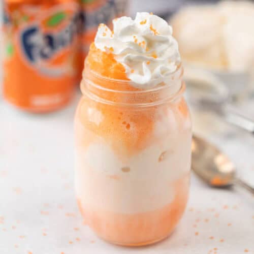 Fanta float in a mason jar topped with whipped cream.