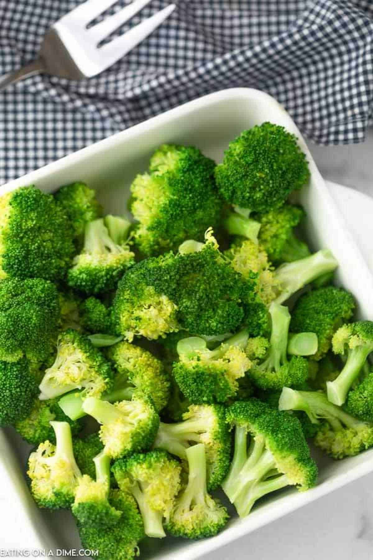 Learn how to steam broccoli in microwave. This easy and healthy side dish takes only 3 minutes! Enjoy tender broccoli in minutes. Steamed broccoli in a white dish