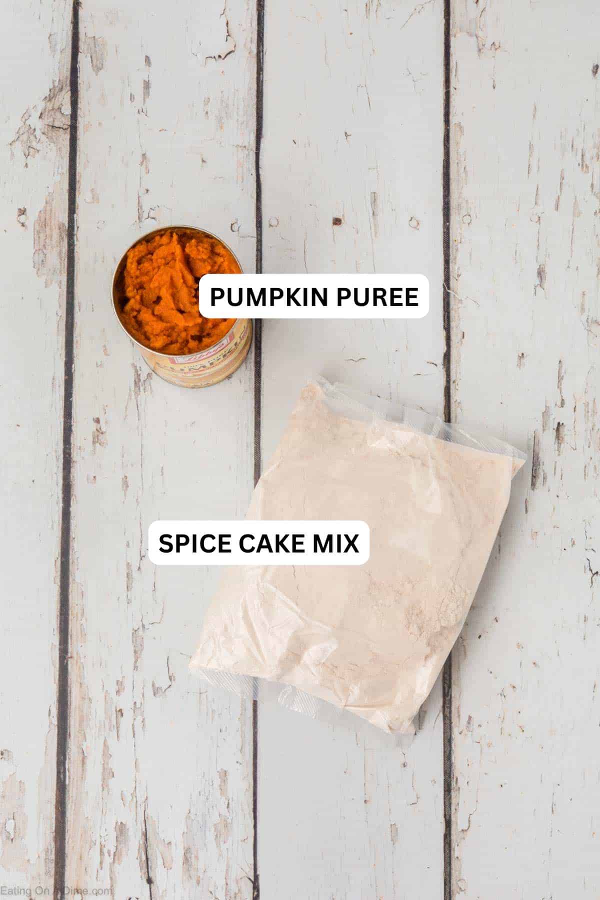 An open can of pumpkin puree and a sealed plastic bag of dry ingredients sit on a rustic wooden surface, hinting at the simplicity of 2 Ingredient Pumpkin Muffins. The dry ingredients appear to be a powder or flour mix, possibly for baking these easy treats.