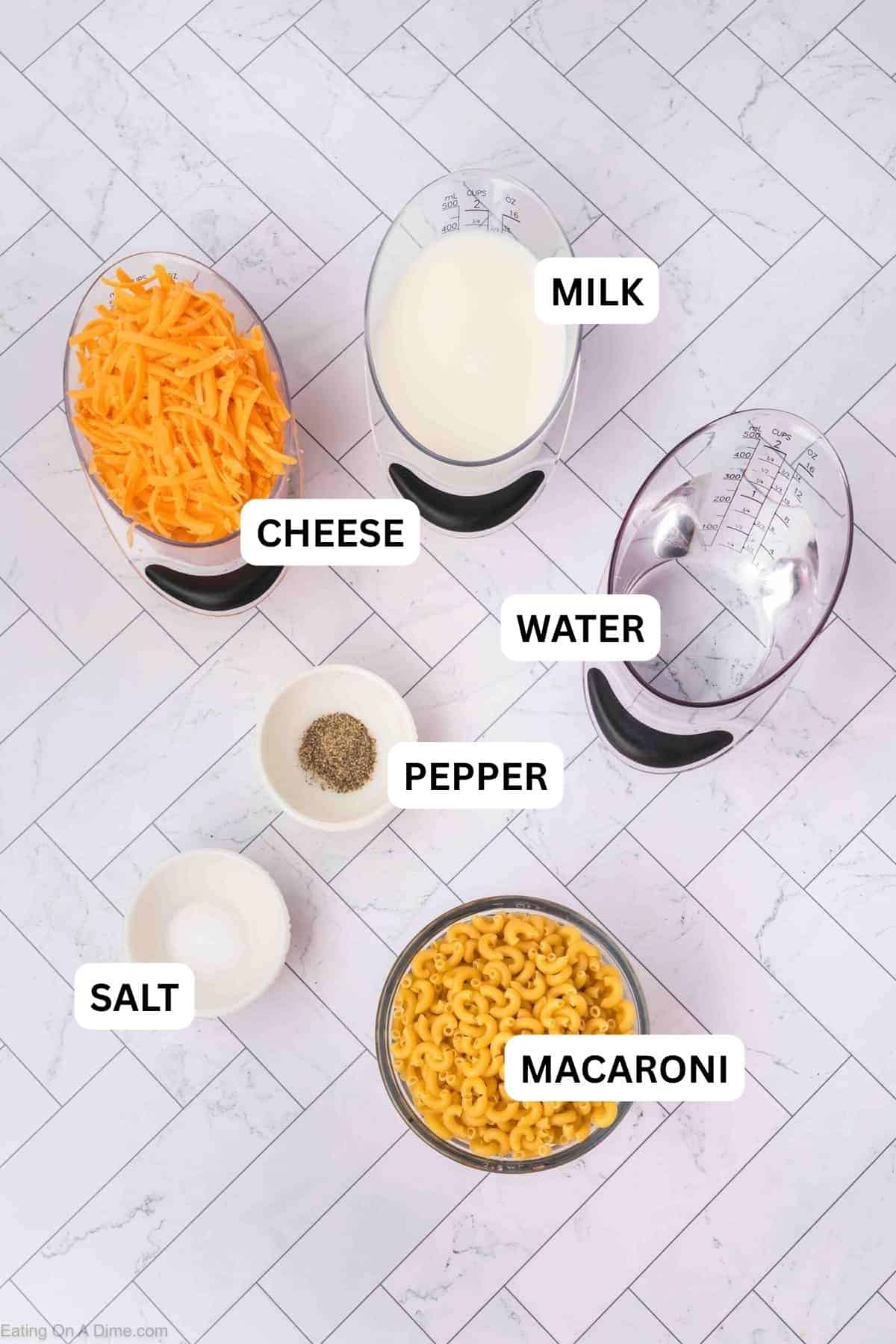 Ingredients needed for this recipe Includes grated cheddar cheese, milk, pasta, salt, and pepper in separate bowls and measuring cups.