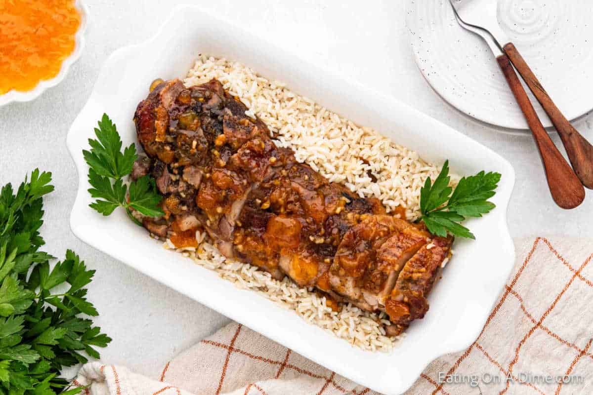 Pork Tenderloin with peaches on a platter with rice.