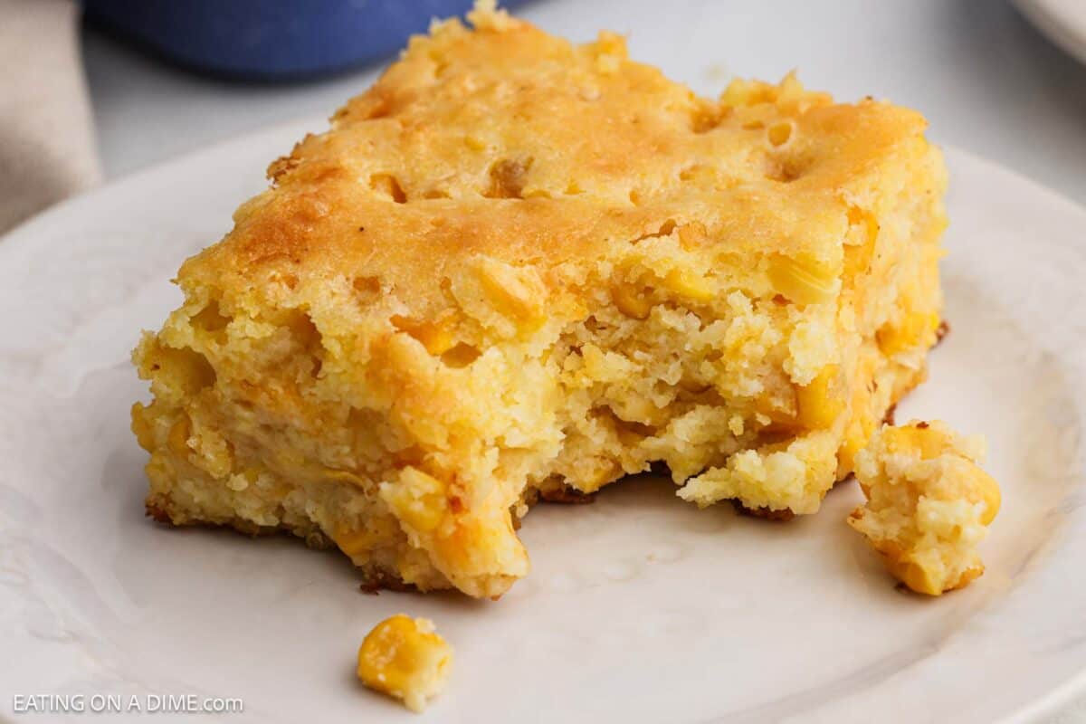 A serving of this easy cornbread casserole recipe on a white plate.