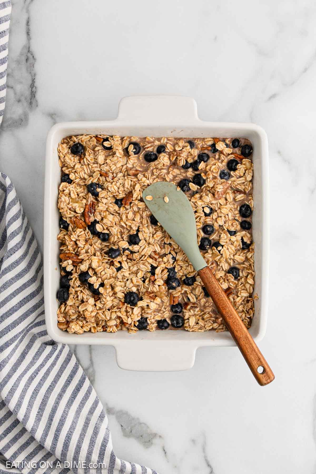 Spreading the oat mixture in a baking dish with a spatula