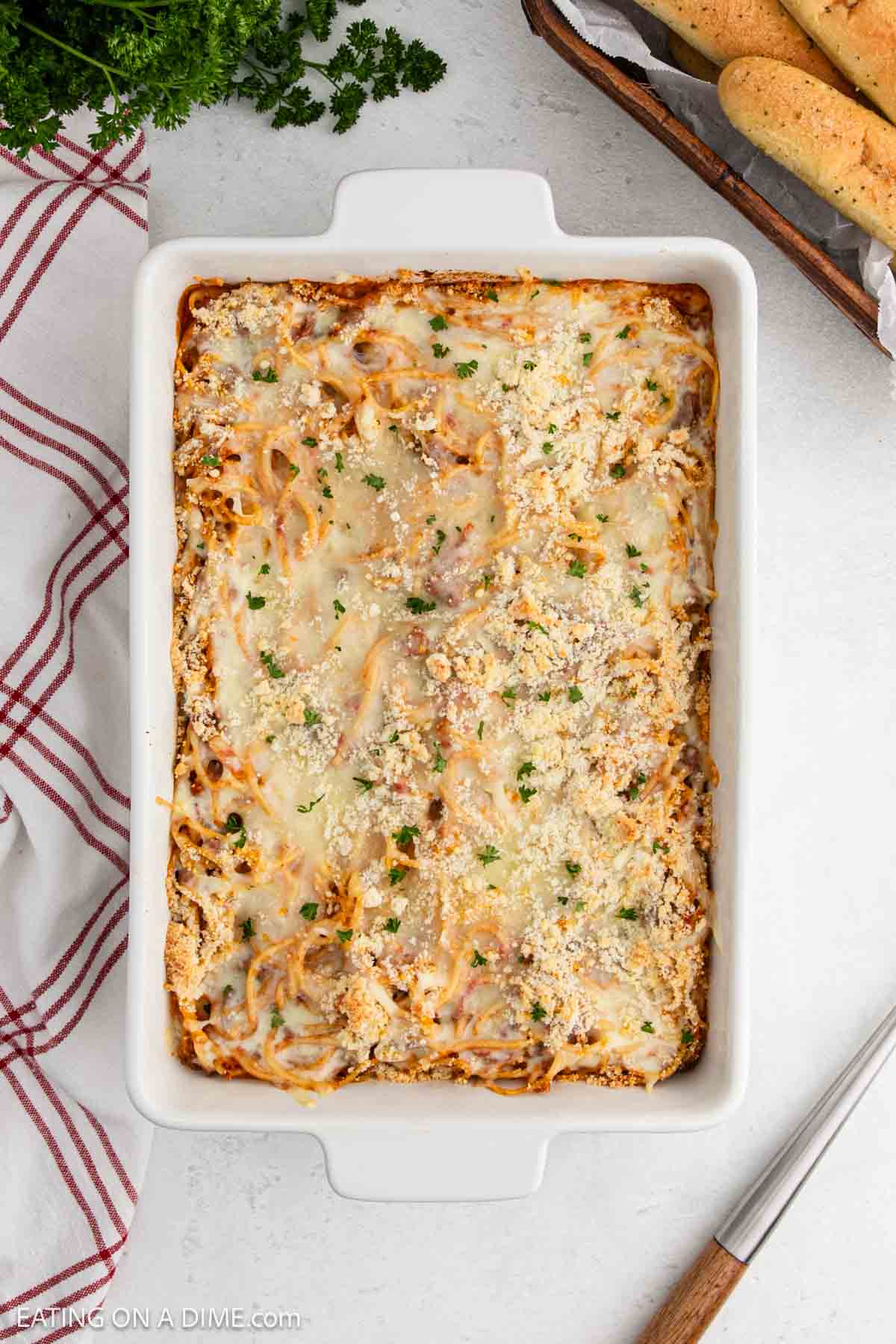 Baked Spaghetti in a casserole dish topped with melted cheese