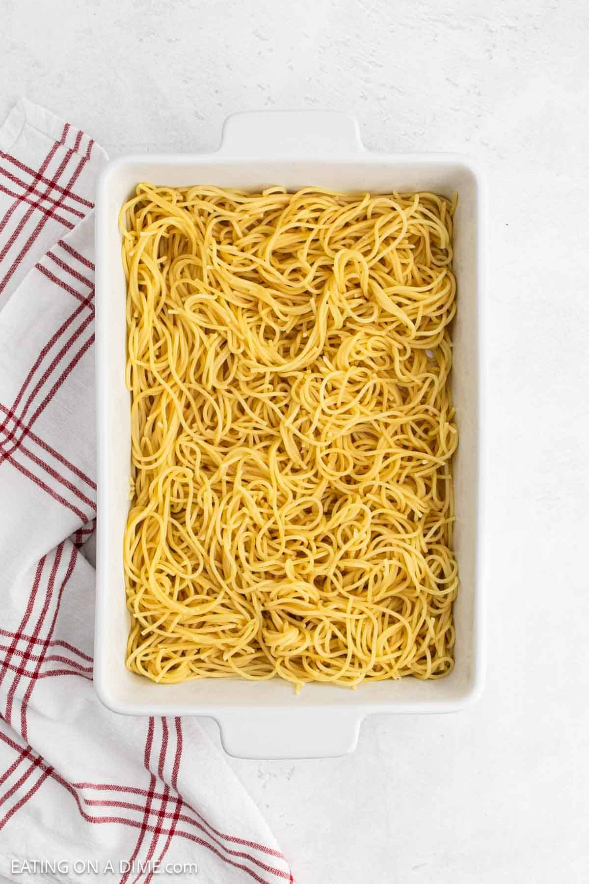 Cooked spaghetti noodles in a baking dish