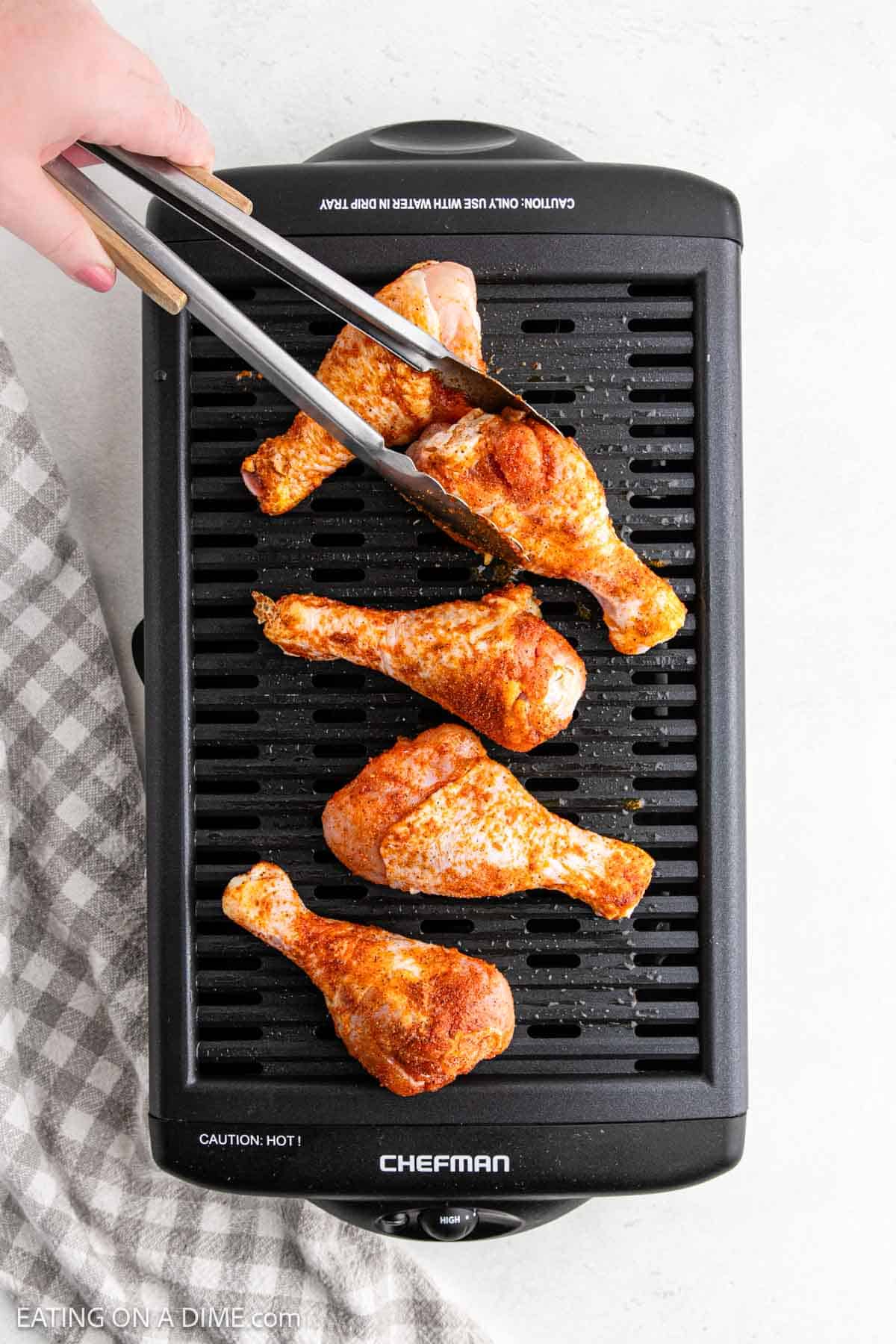 Placing the chicken legs on the indoor grill