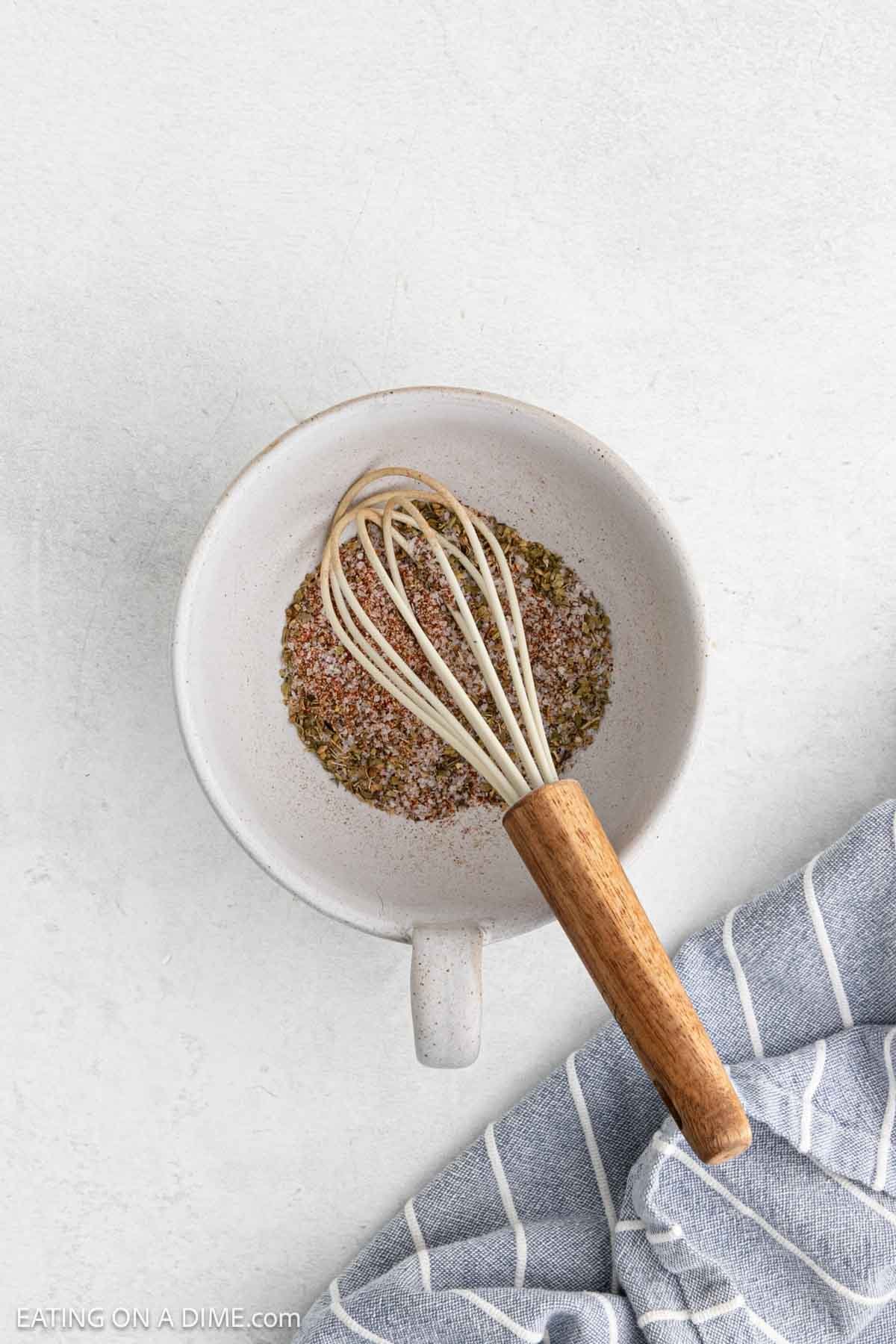 Combining the seasoning in a bowl with a whisk