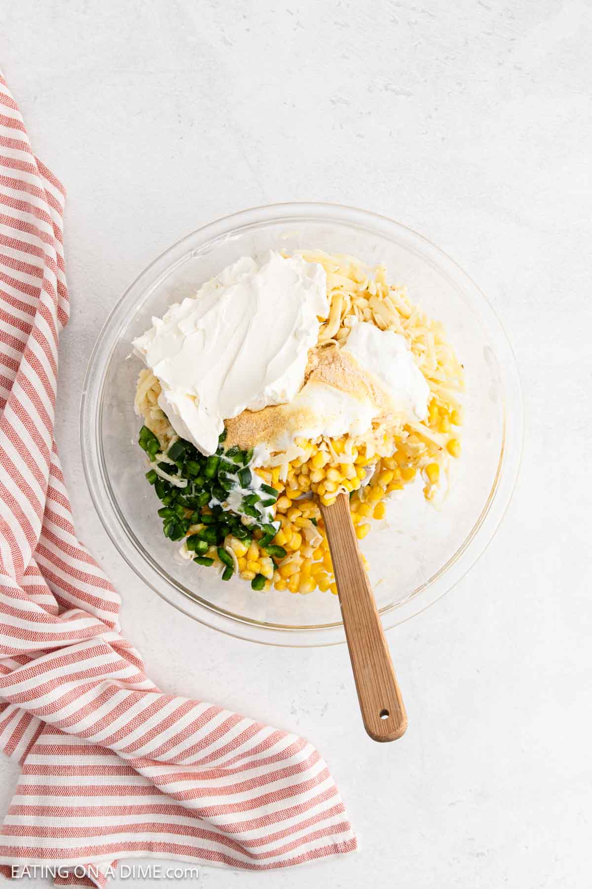 Ingredients added to a bowl with a wooden spoon