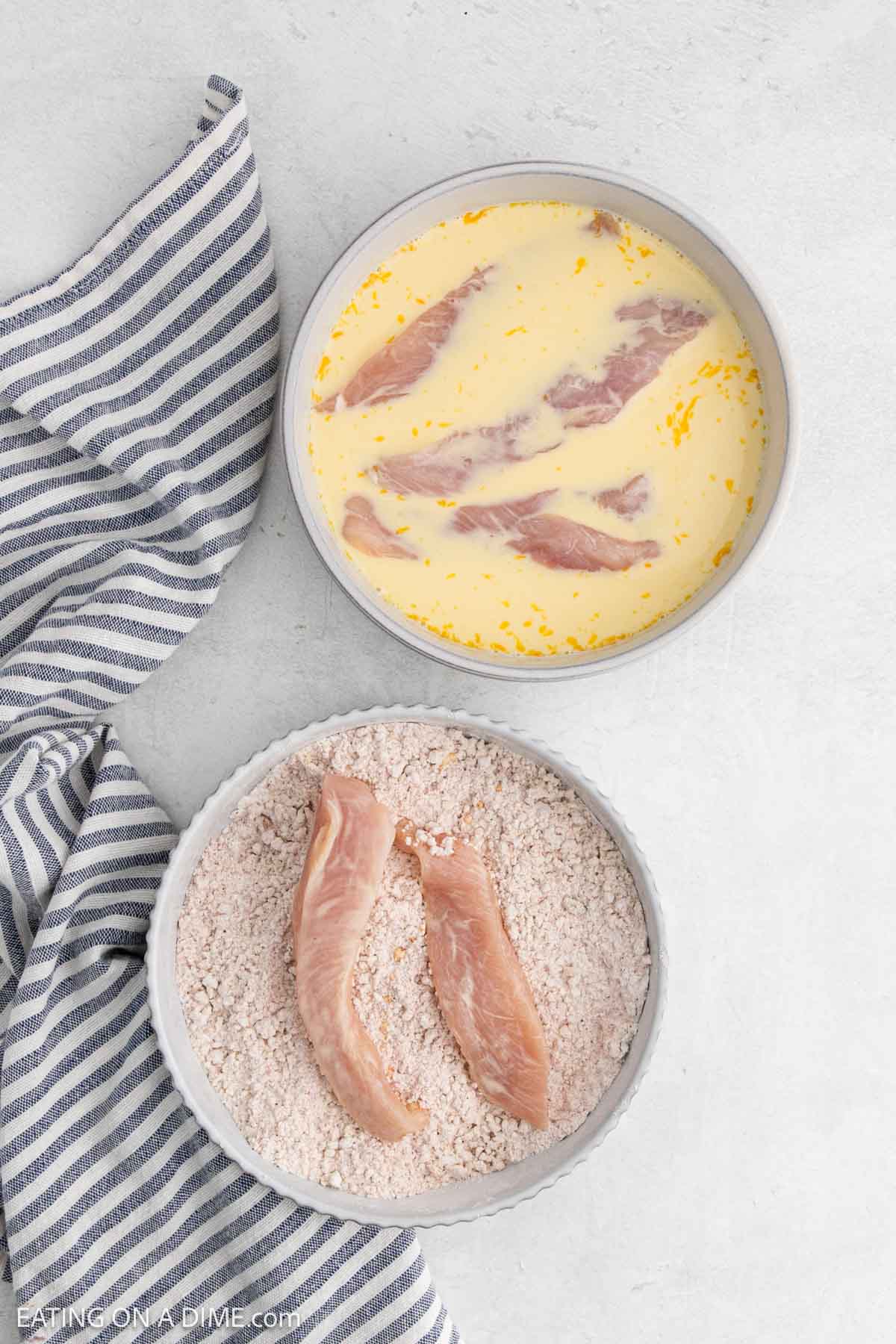 Placing the chicken tenders the bowl with the egg and milk mixture and the seasoning mixture