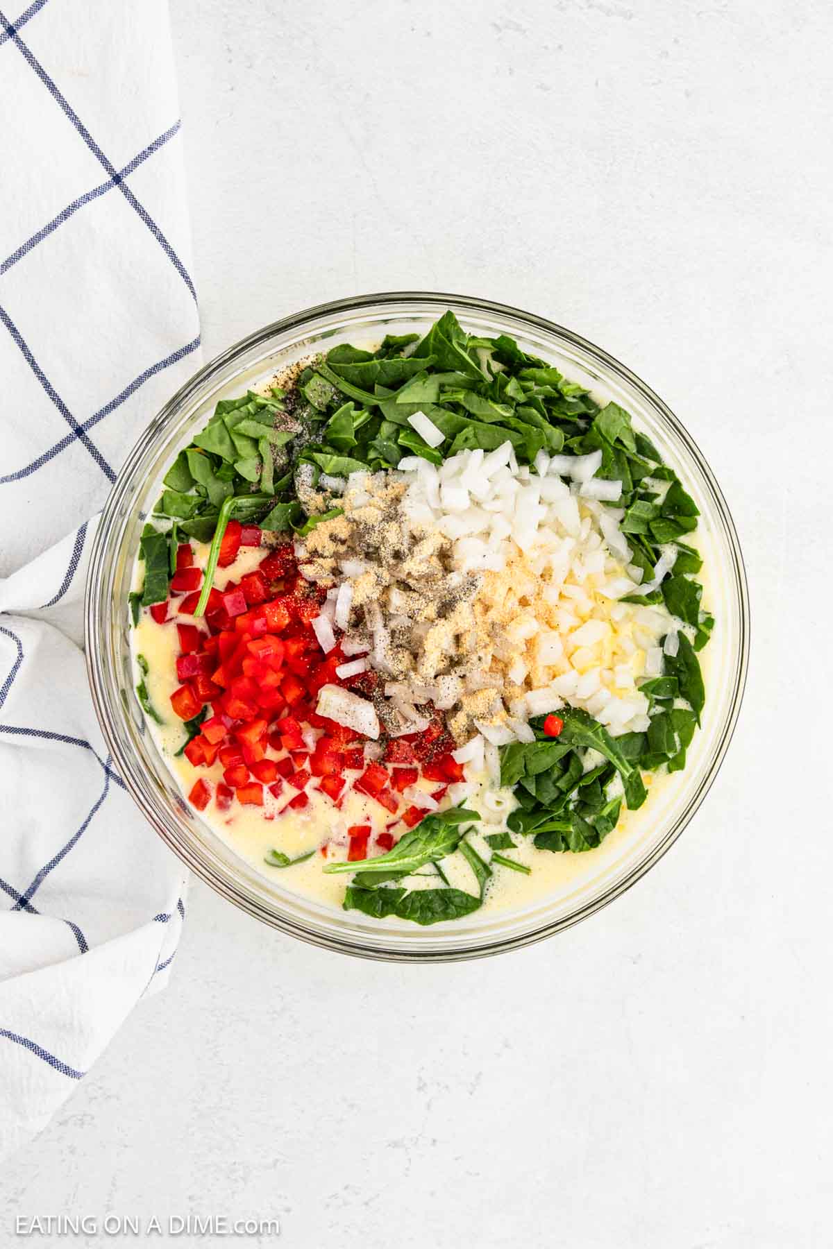 Chopped spinach, chopped onions, red bell pepper and seasoning mixed with the egg mixture
