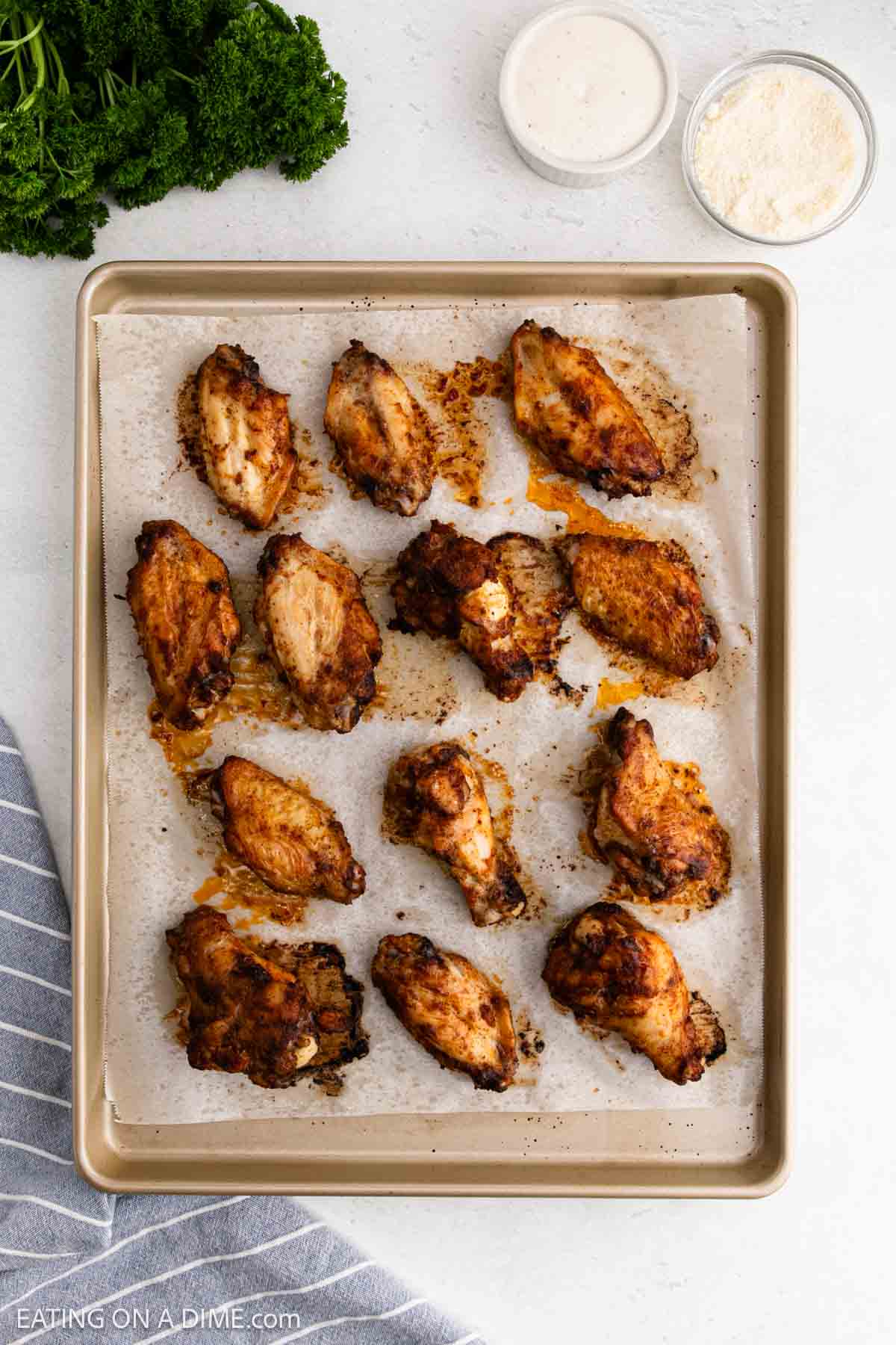 Cooked chicken wings on a baking sheet with parchment paper