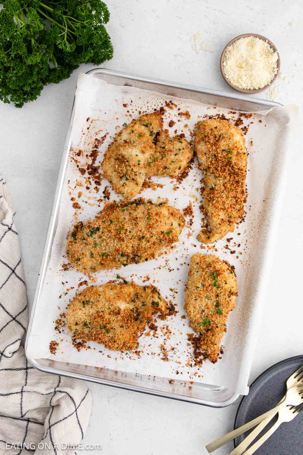 Baked chicken breast on a baking sheet lined with parchment paper