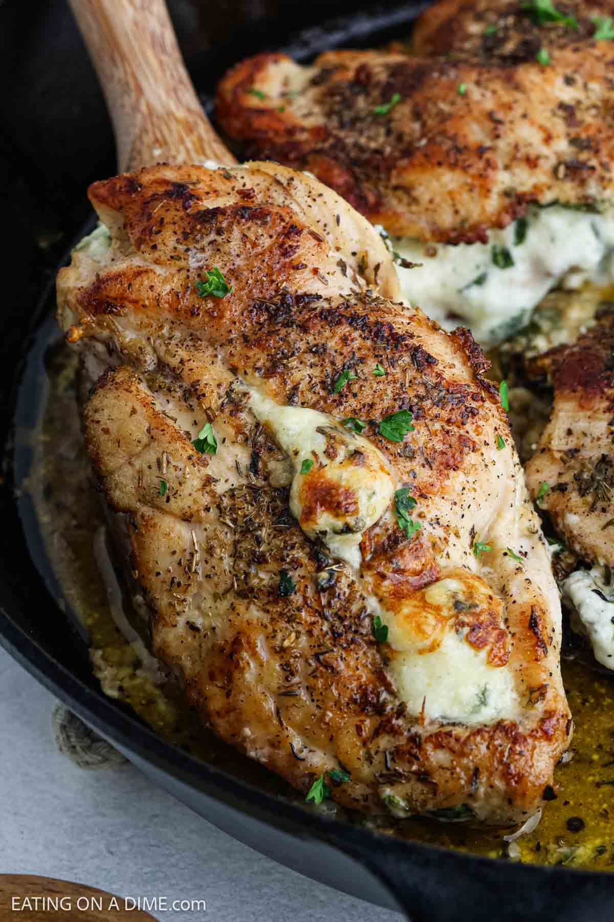 Seasoned stuffed chicken breast filled with melted cheese, herbs, and tender spinach, cooked to perfection in a skillet. Perfect for those seeking flavorful and easy chicken recipes.