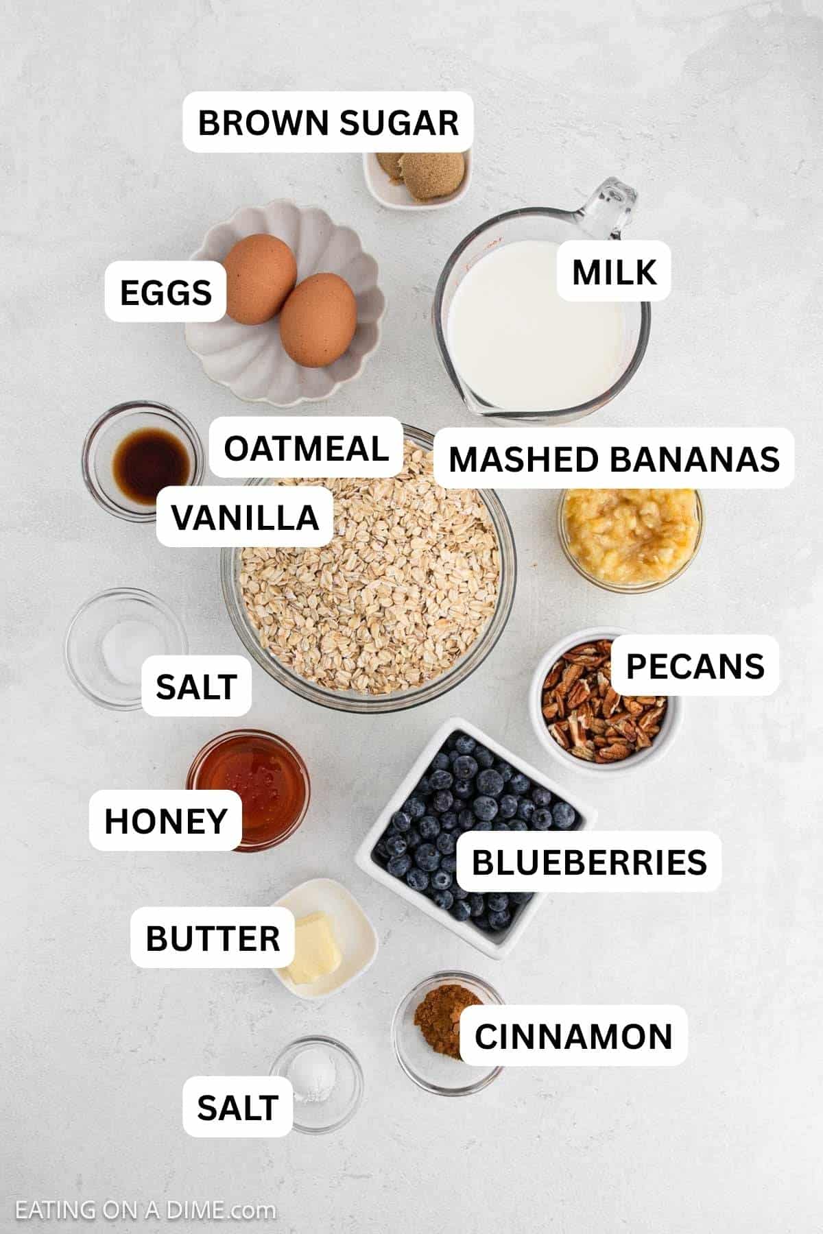 Ingredients needed to make this recipe which includes Bananas, milk, maple syrup, eggs, butter, brown sugar, vanilla extract, oats, baking powder, cinnamon, salt, pecans, and blueberries.