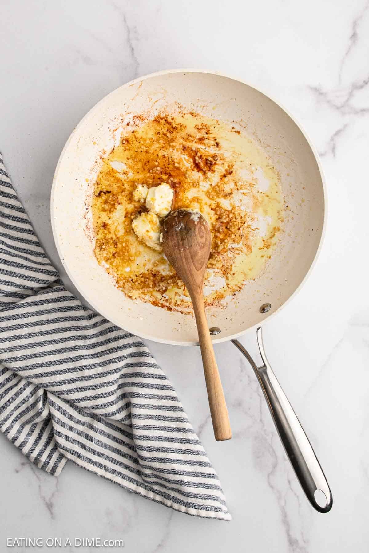 Melting butter in a skillet with a wooden spoon