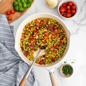 A skillet filled with vegetables and tomatoes.