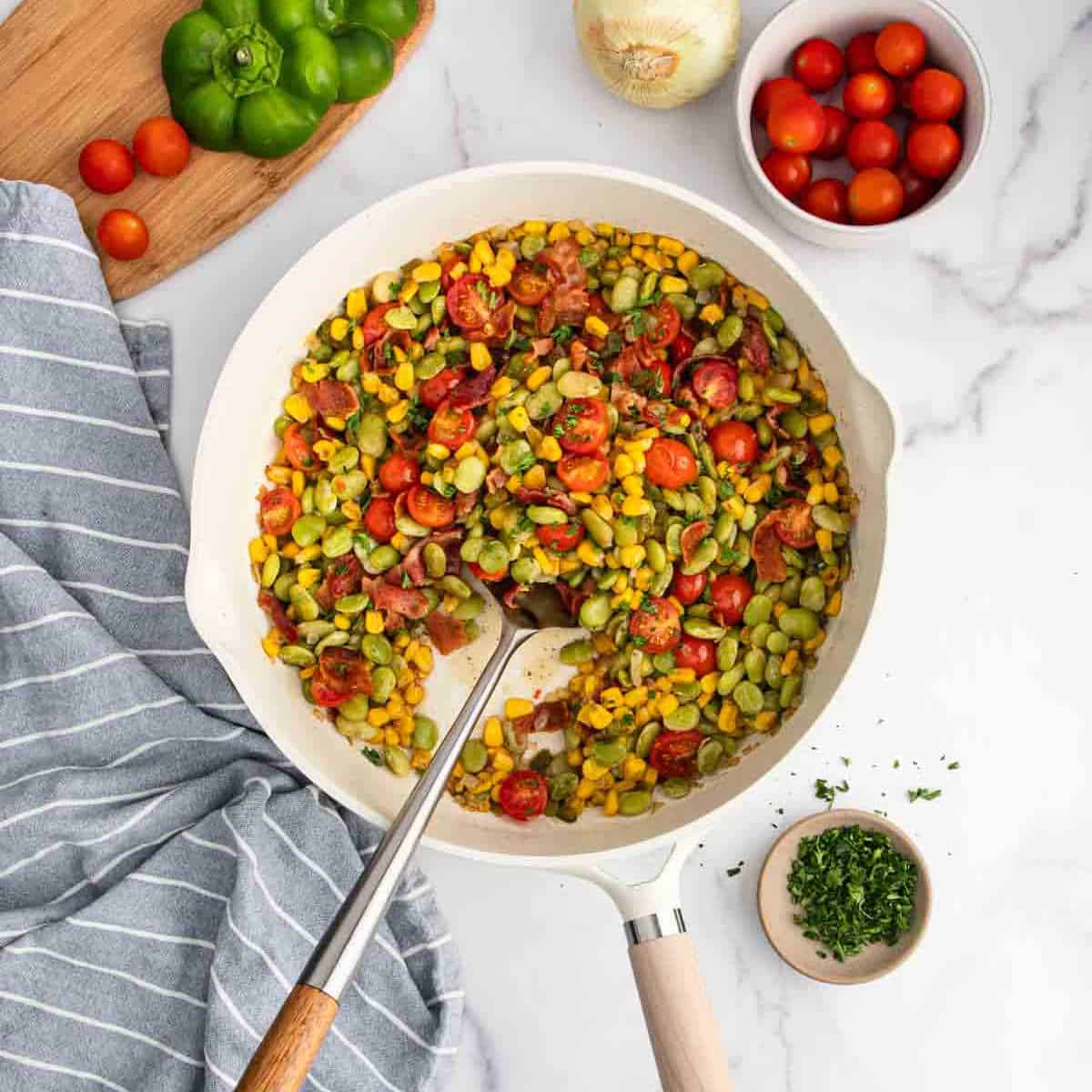 A skillet filled with vegetables and tomatoes.