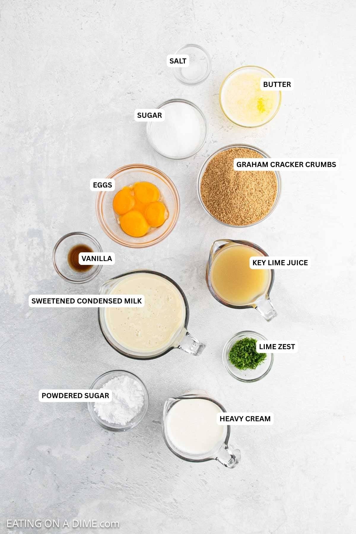 Ingredients for recipe: salt, butter, sugar, graham cracker crumbs, eggs, key lime juice, vanilla, sweetened condensed milk, lime zest, powdered sugar and heavy cream.