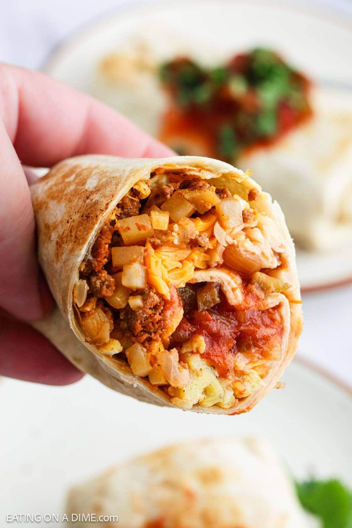 Breakfast Burrito being held up close showing the chorizo filling