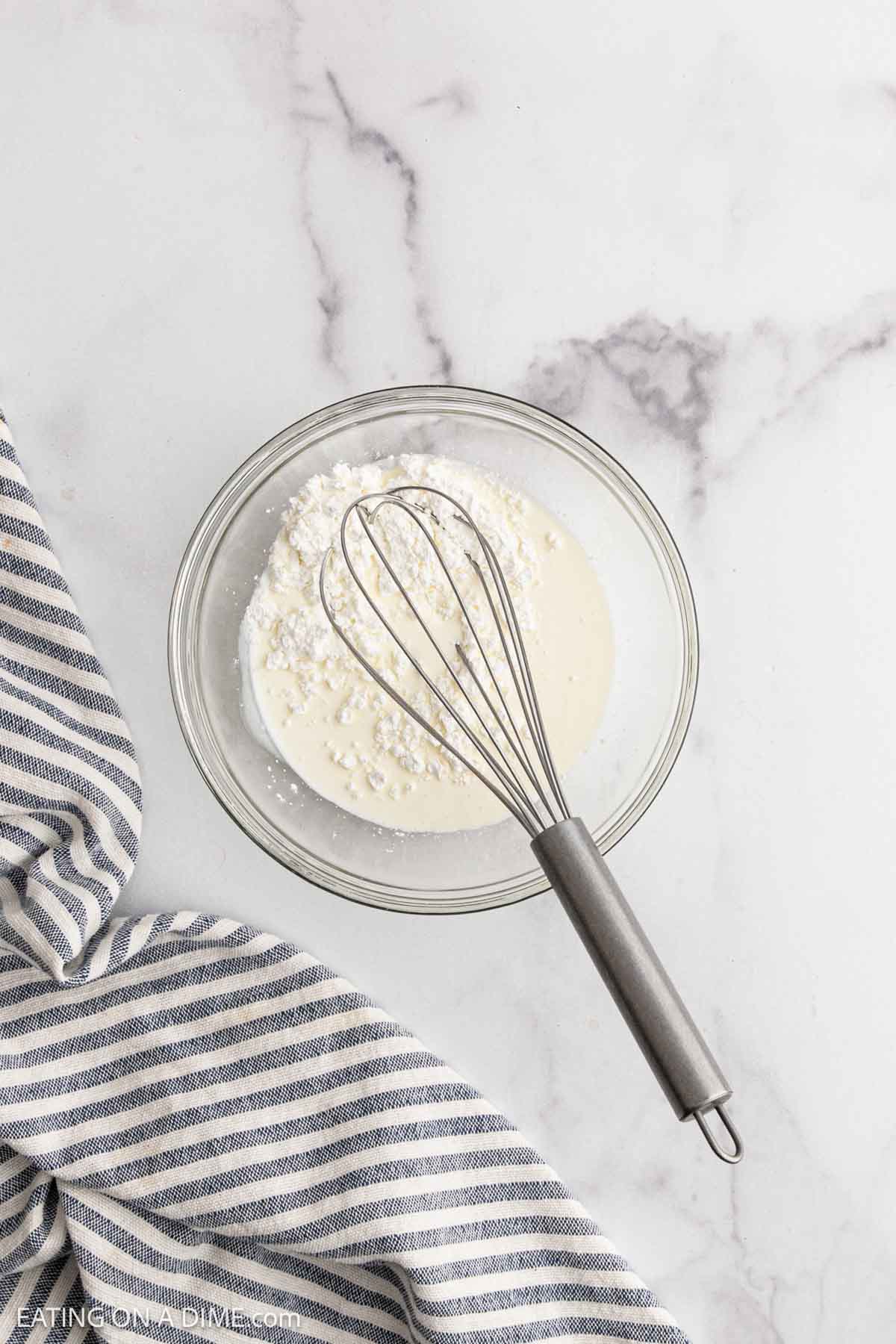 Combining the cornstarch and heavy cream in a bowl with a whisk