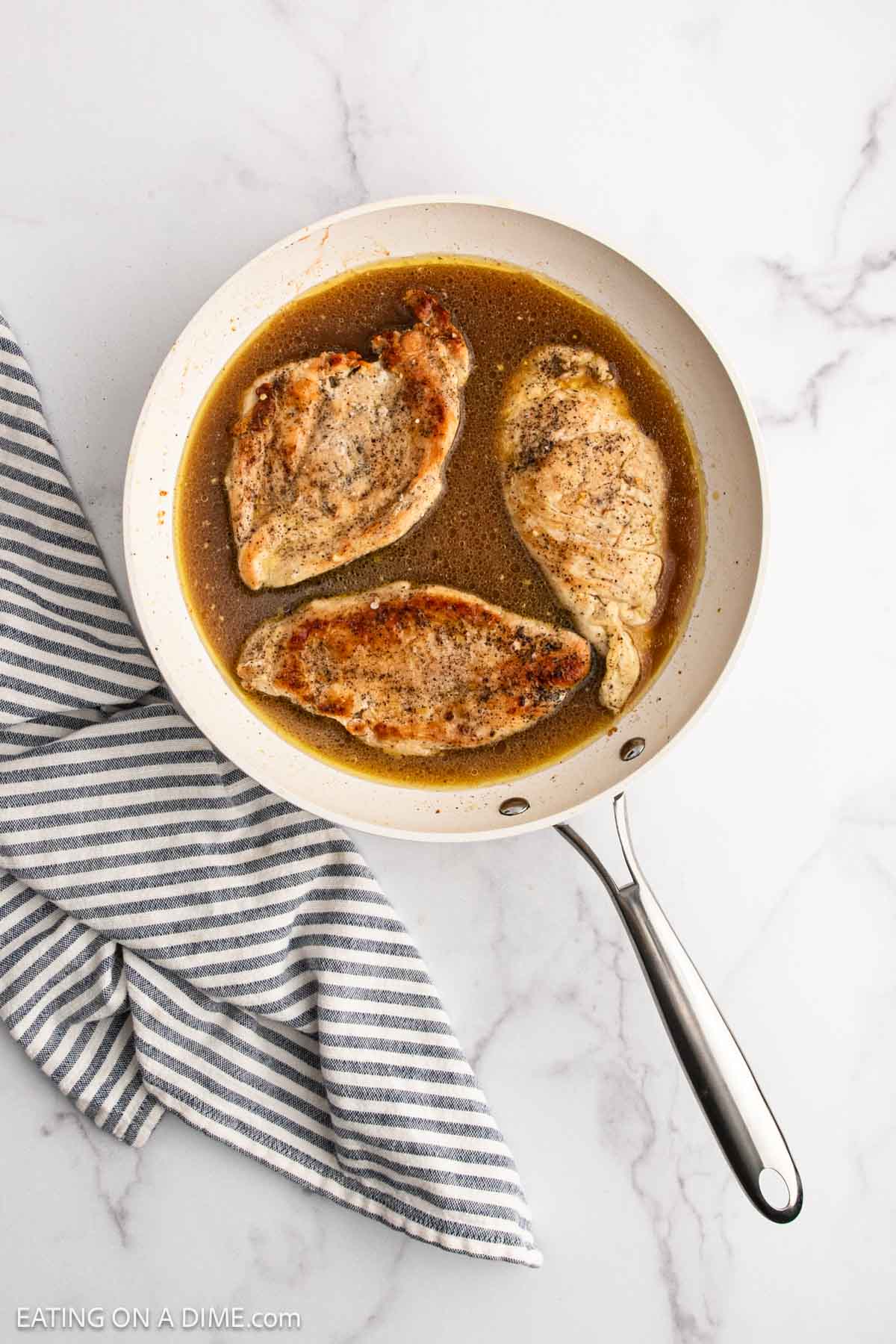 Cooked chicken breast in the skillet with the broth
