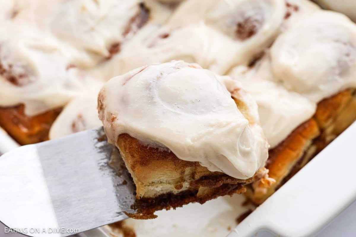 Hawaiian Cinnamon Roll in a baking dish with a serving on a spatula