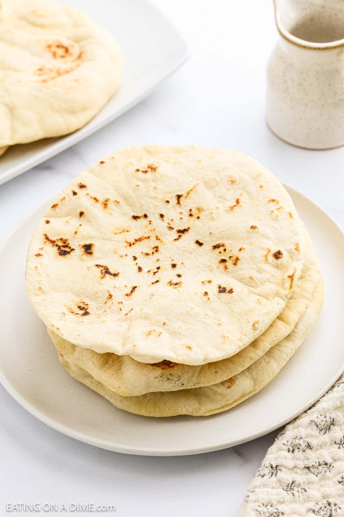 Pita bread stacked on a white plate