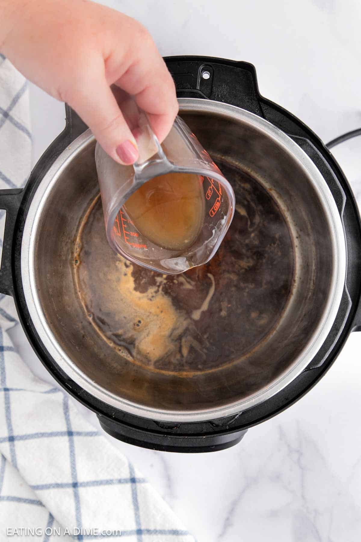 Pouring chicken broth to the instant pot