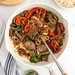 Beef stir fry in a white pan.