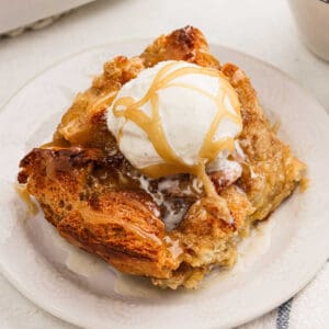 A serving of bread pudding on a plate topped with ice cream.