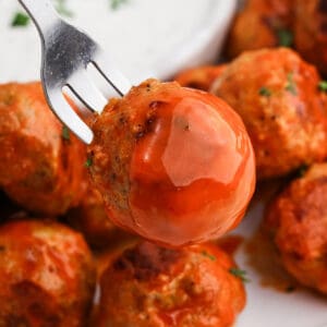 Buffalo Chicken meatballs on a plate with a serving on a fork.