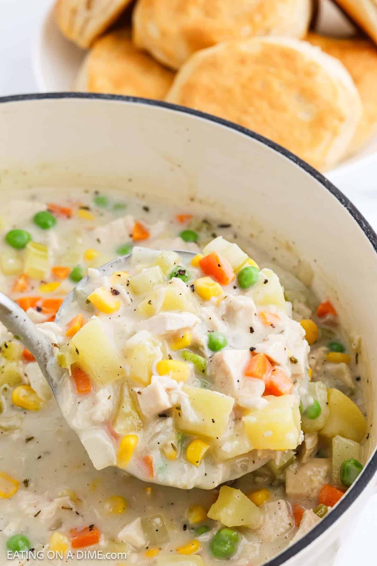 A spoon in a pot of Chicken Pot Pie Soup.