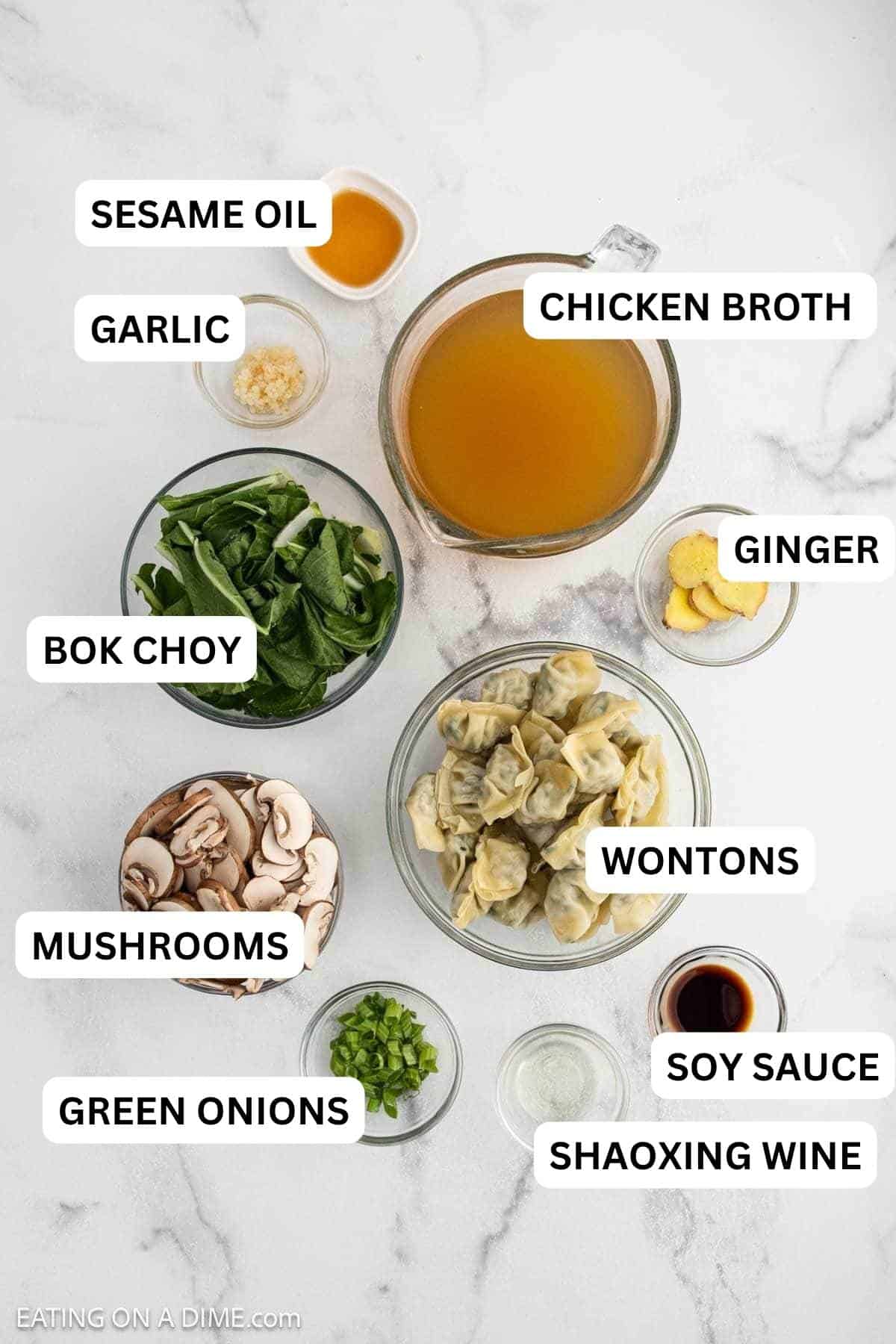 Ingredients needed for this recipe including dumplings, sliced mushrooms, spinach, broth, ginger slices, chopped green onions, minced garlic, soy sauce, and oil in separate bowls.