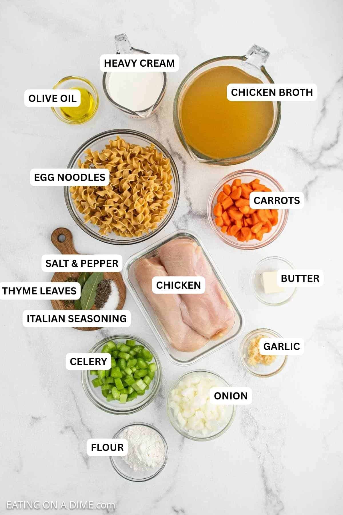 Ingredients for recipe: raw chicken breasts, dry egg noodles, chopped carrots, celery, diced onion, garlic, flour, butter, olive oil, seasonings, chicken broth, and cream.
