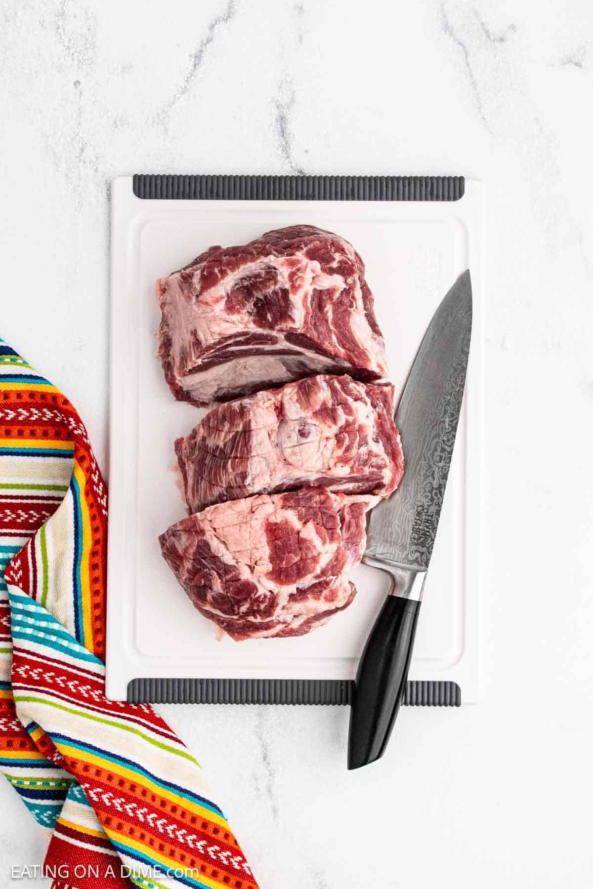 Sliced pork roast on a cutting board with a knife.